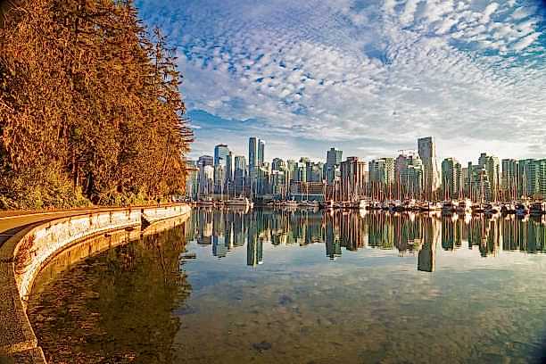 Vancouver Downtown at Autumn Time Beautiful view of Vancouver skyline with Stanley Park modern buildings and s sea wall walking path on the background of cloudy sky BC Canada